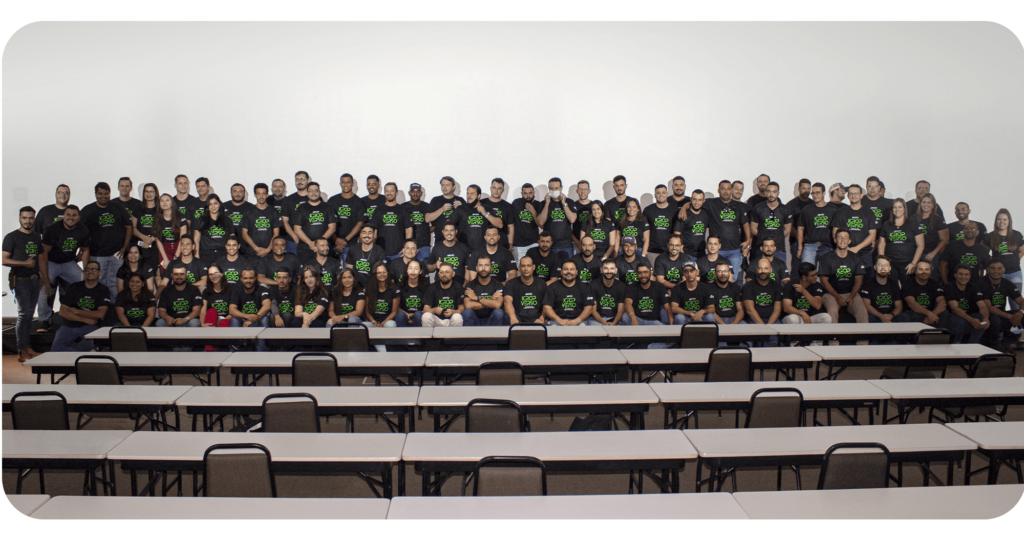 A imagem retrata toda a nossa equipe, unida em harmonia, posicionada no palco, formando uma foto cativante que reflete o espírito colaborativo.